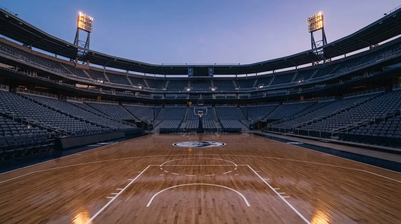 An empty football stadium with floodlight masts at dusk