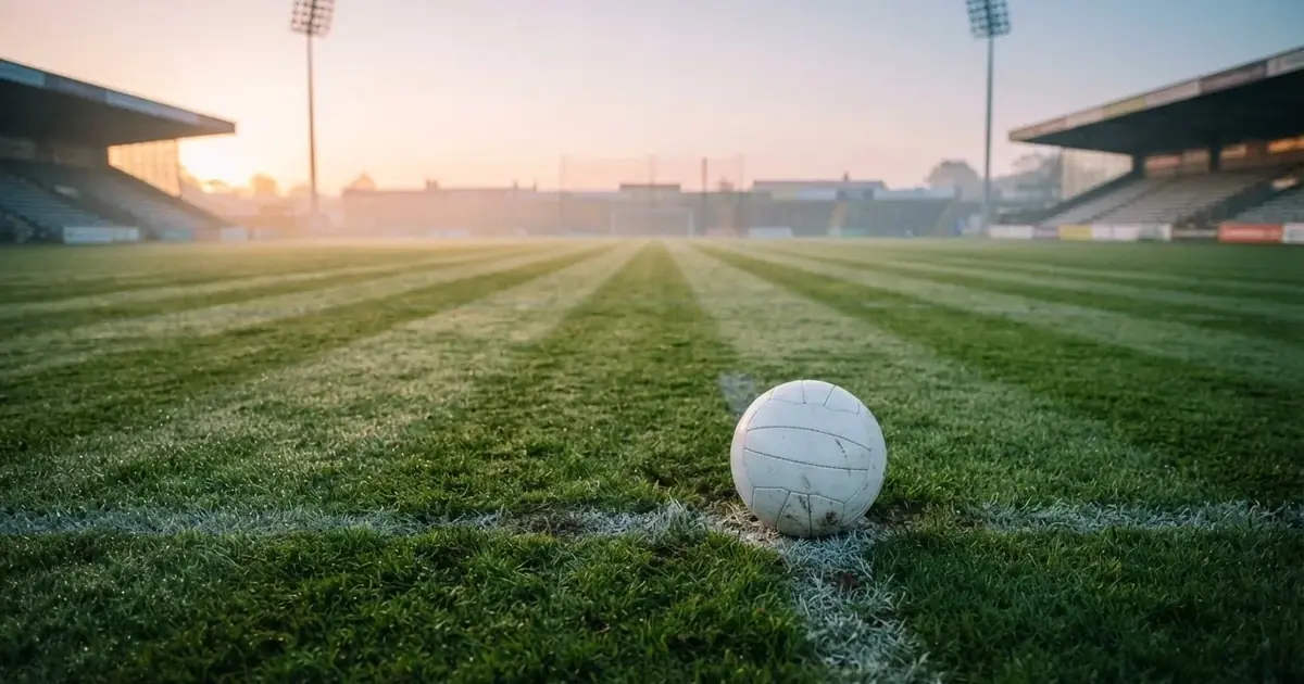 A ball on the centre spot of a grass pitch in morning light