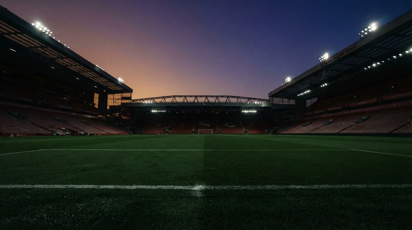 An empty football stadium with floodlight masts at dusk