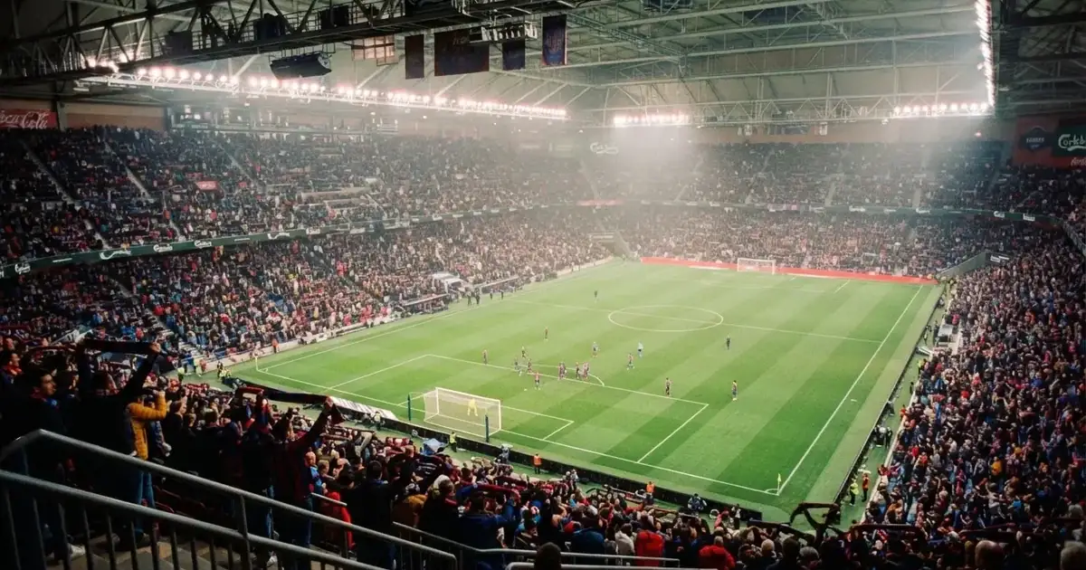 A packed sports hall under floodlights photographed from a long way off